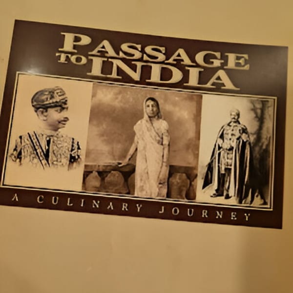 Passage to India restaurant's sign with three sepia-toned portraits of Indian people.