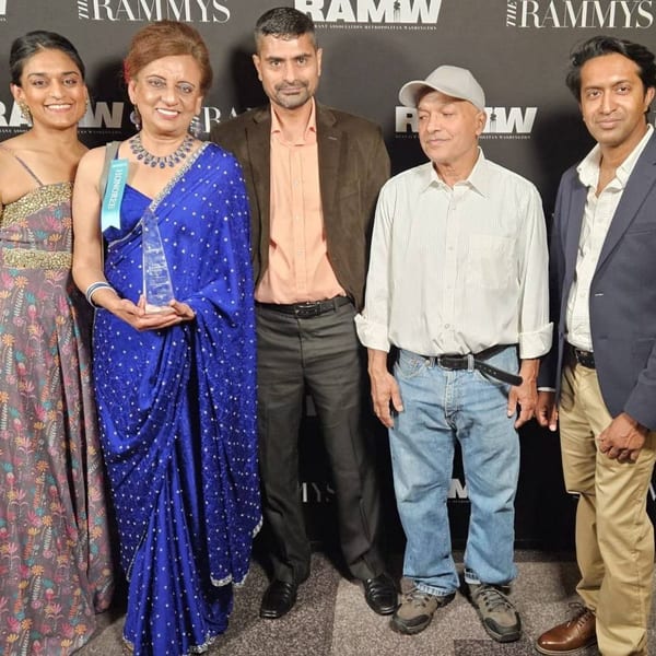 Five people from Passage to India, including a woman holding an award, pose at The RAMMYS.